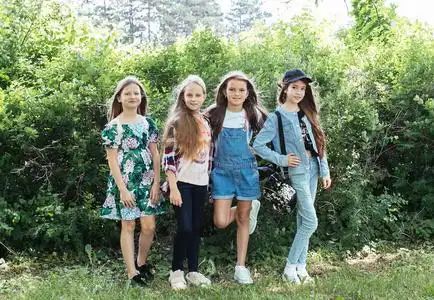 四个女孩在绿色公园散步,欢笑和玩耍,以获得一个积极的女学生女友照片