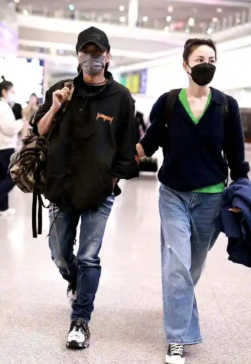 王菲谢霆锋挽手走机场,休闲装扮简约接地气,扎丸子头好清爽!