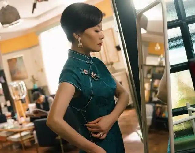 在曝光的剧照中邬君梅,邬君梅身着藏蓝色旗袍邬君梅,化着精致的妆容