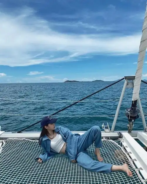欧阳娜娜出海游玩躺甲板上显惬意 穿蓝色牛仔套装秀蛮腰