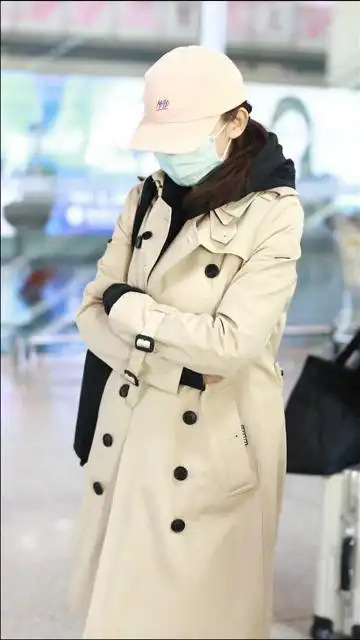 机场直拍热依扎穿风衣露纤细美腿戴小粉帽清新减龄低头疾走