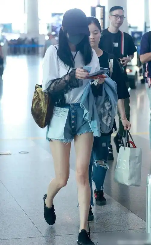 杨幂机场亮相被偷拍穿简约白t搭牛仔短裤背个金包怪洋气