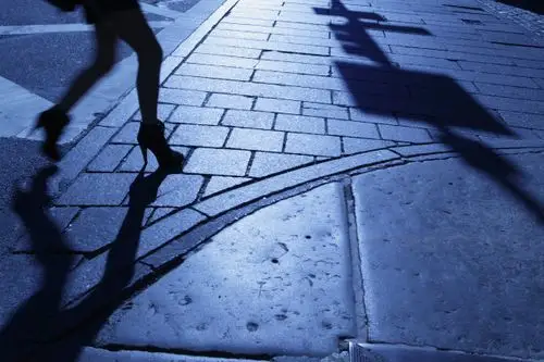 雨后在潮湿的街道上行走的一个不认识的人的影子图片-商业图片-正版