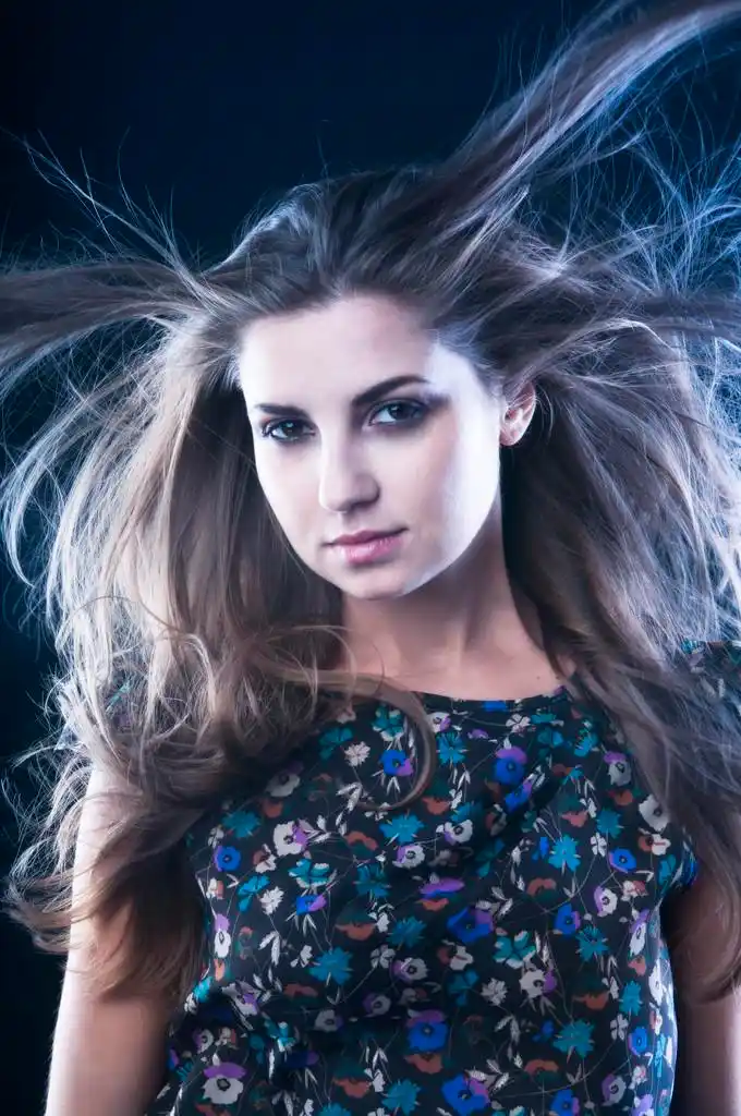 头发飘扬的女人,美丽的女子和飞舞的深蓝色背景上的头发