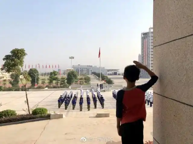 孩子,你向国旗敬礼的背影真好看.(广西消防)