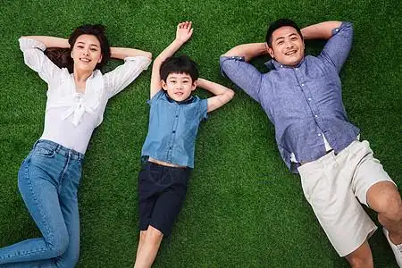 亲情减压青年男人幸福的一家三口躺在草地上图片素材