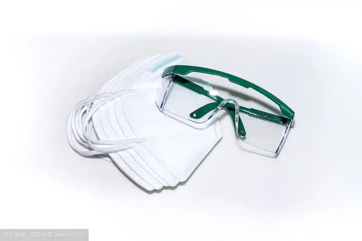 白背景板上的口罩与护目镜