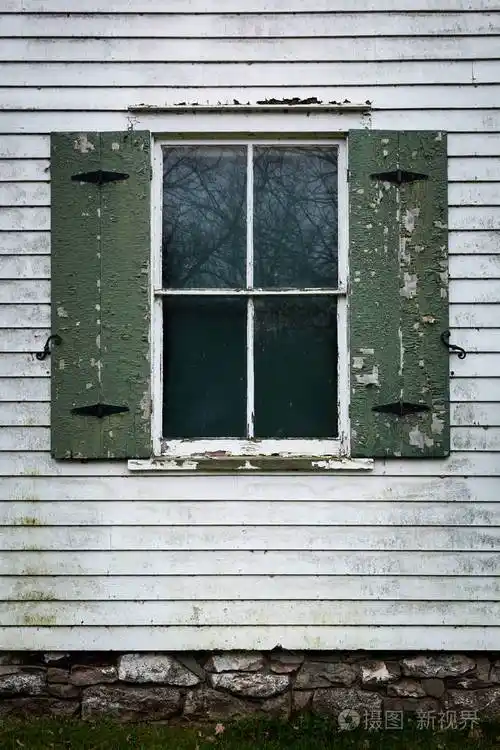 一扇旧玻璃窗被剥落的油漆环绕需要修理