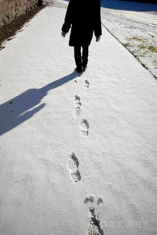 路面雪地里反射出的脚印雪地里的脚步声冬季小径你的举动雪上行走雪上