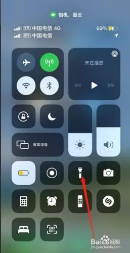 我们就可以上滑打开手机的控制中心,点击手电筒图标