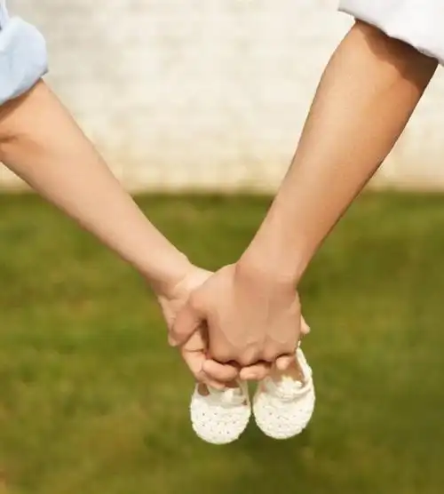 而另一张照片则是两人用手比成心形,宝宝的脚丫放在中间,两个人的小