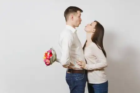 男生日热恋中的情侣女人躲在身后的男人背后藏着一束美丽的玫瑰花, 在