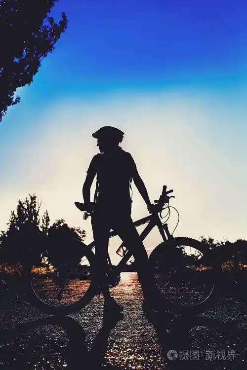 夏日夕阳下骑自行车的女孩剪影