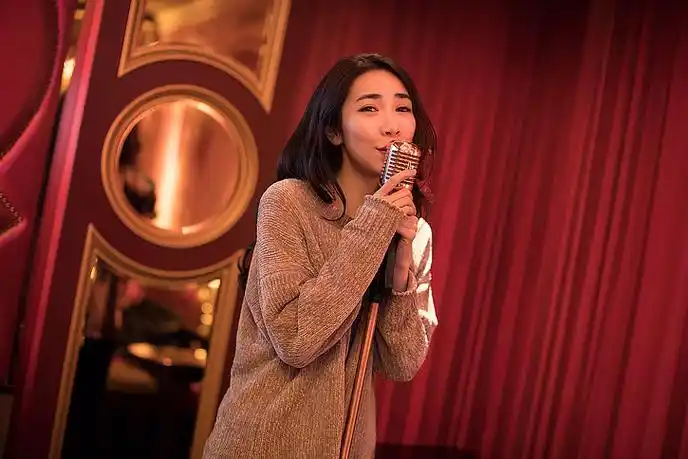 快乐的年轻女士在ktv唱歌