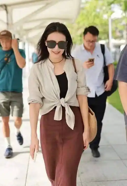 在这个忽冷忽热的春季,高圆圆身着一件长款的墨绿色风衣,搭配牛仔裤