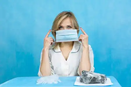 呼吸器官女实验室技术员戴上口罩.