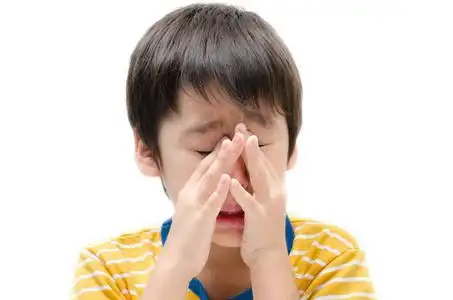 在白色哭小男孩哭 ichy 他的眼睛在白色背景照片