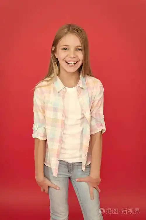 快乐的童年.女孩可爱的孩子在红色背景上的笑脸表情.积极情绪概念.