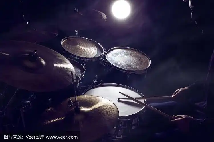 那个男人在昏暗的背景下打架子鼓