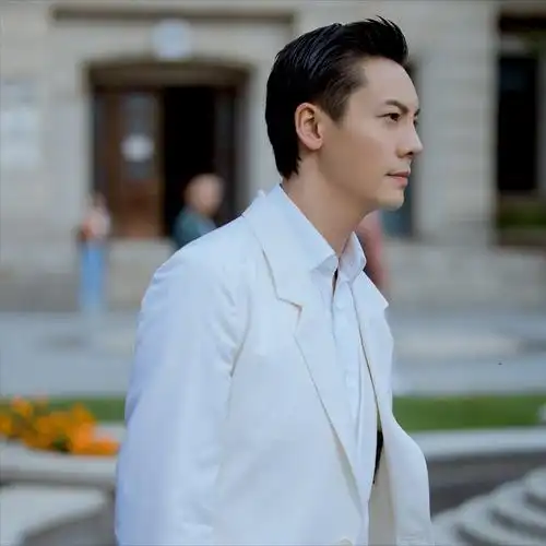 陈伟霆梳理着一款二八斜背发型,身穿纯白色的西服套装,舒雅大气风度不