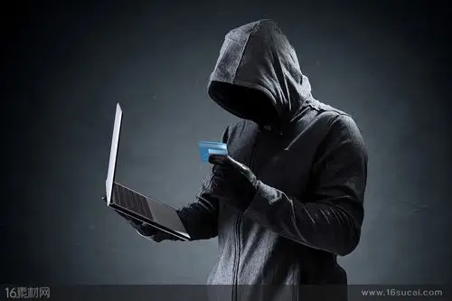 拿着笔记本电脑和卡片的神秘人物高清图片