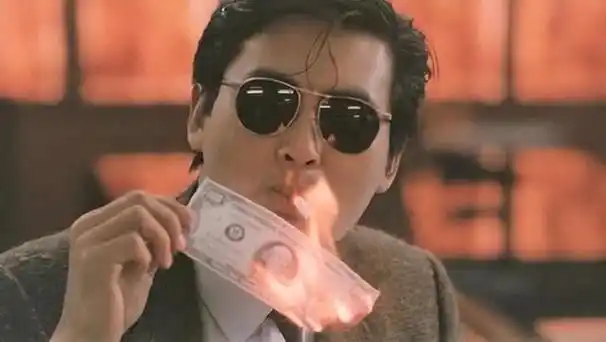 发哥就不一样啦,他在剧里戴着墨镜,拿美元大钞点烟.