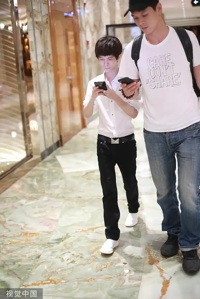 组图:郭敬明脚步匆匆一路低头看手机 与高大男助理显最萌身高差