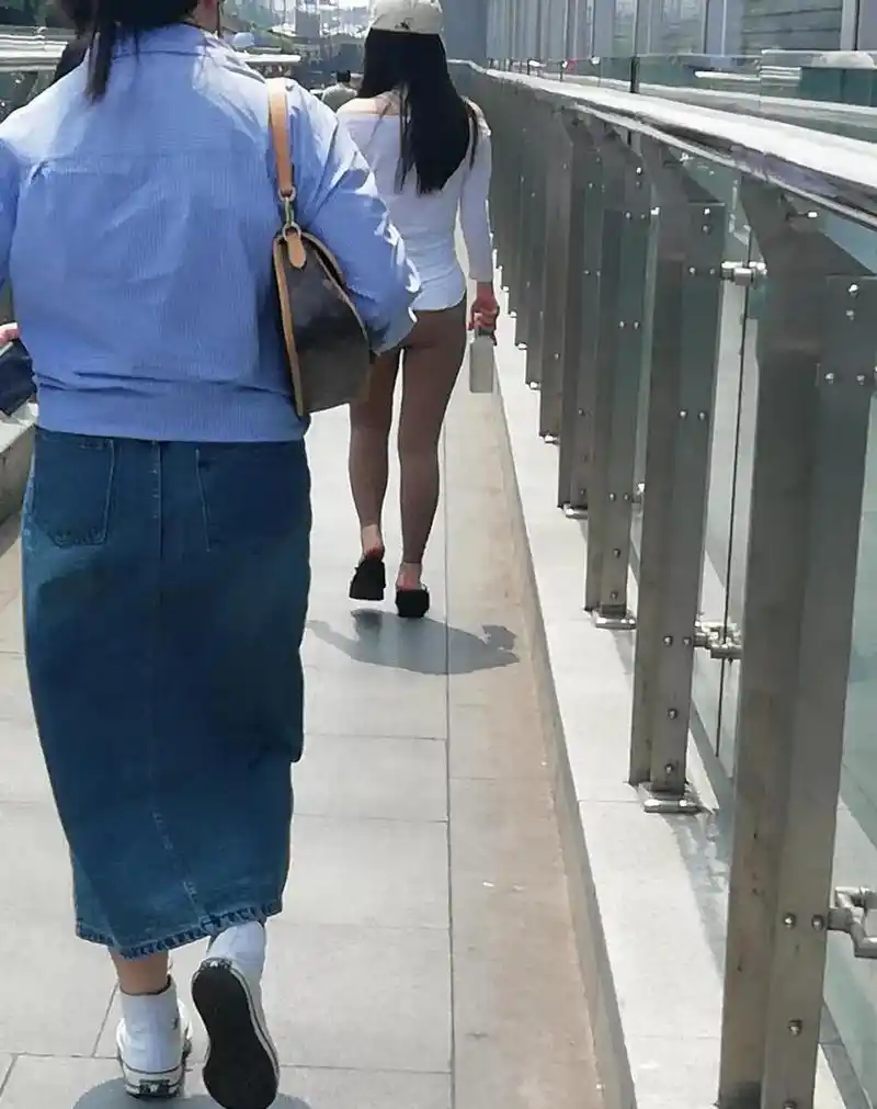一位女士穿着很薄的紧身裤从旁边走过,都勒出了一条缝,回头率杆杠的