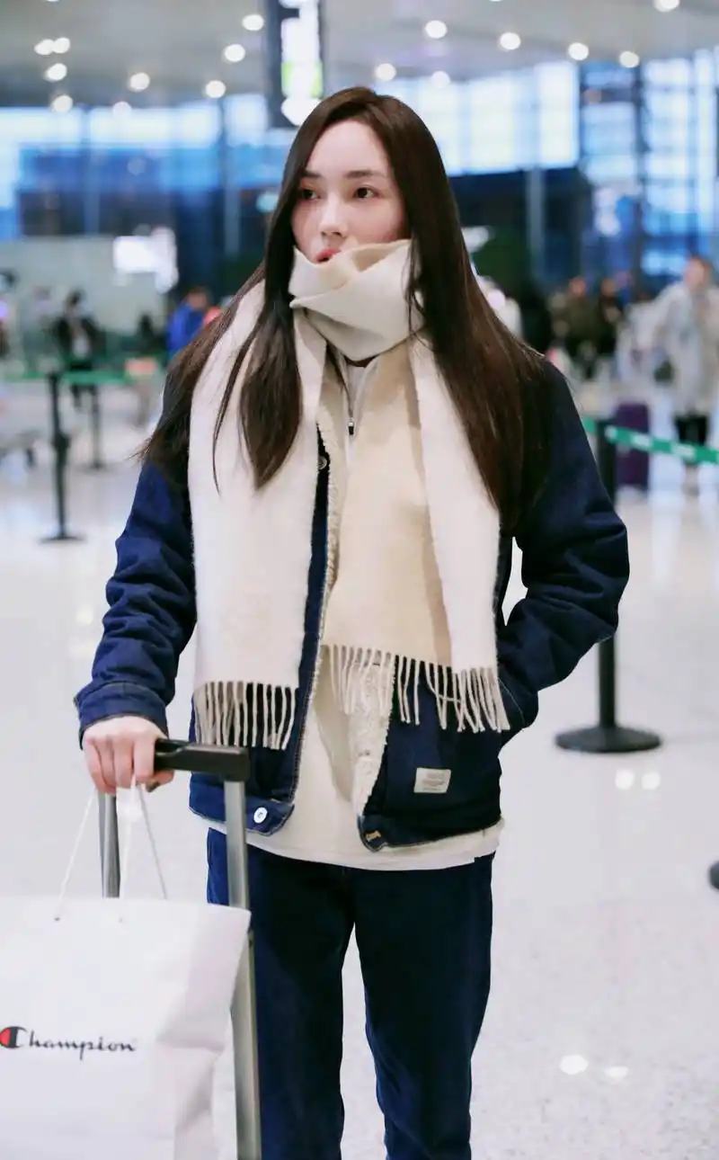 赵嘉敏穿蓝色牛仔衣现身机场,用长围巾遮住半张脸