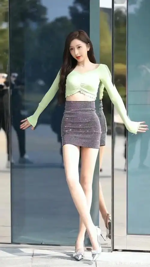 绿色上衣搭配黑色超短裙,一双银白色鞋子成亮点,凸显迷人大长腿