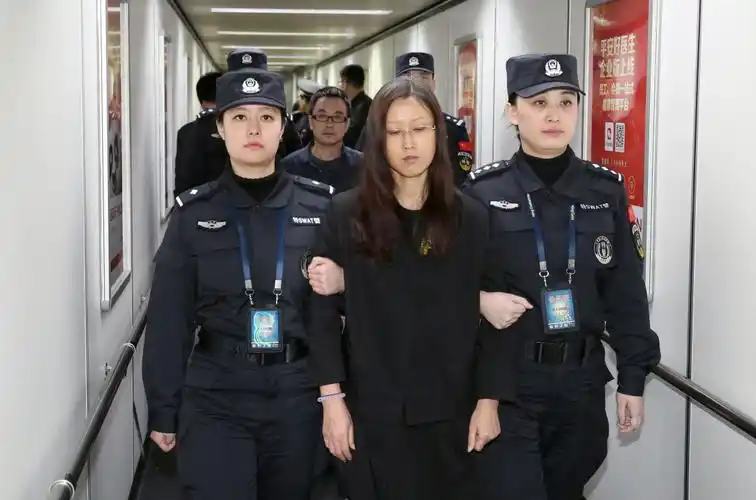 2月6日,在北京首都机场,"百名红通"嫌犯付耀波(后),张清曌(前)被押解