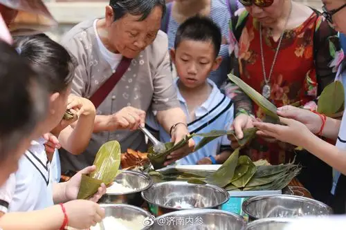 2018年6月18日,山东济南百花洲活动现场开展了包粽子体验活动,市民一