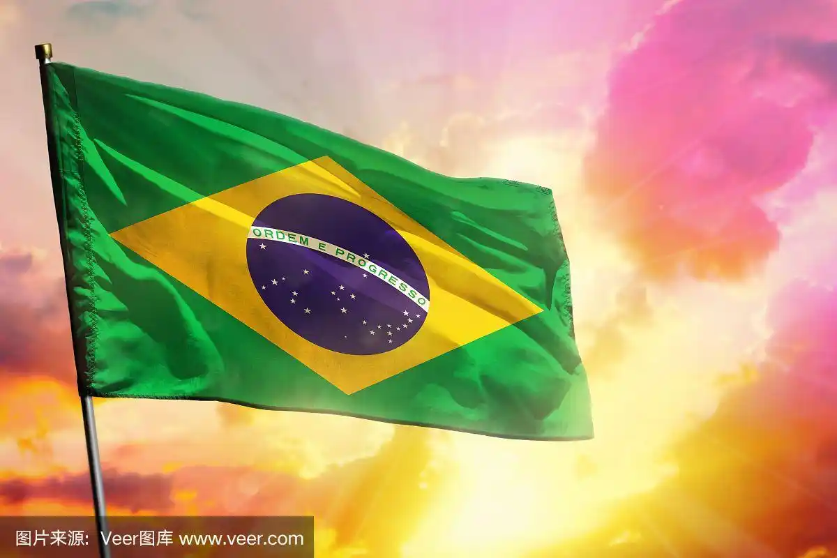 飘扬的巴西国旗上美丽的彩色日落或日出的背景.成功的概念.