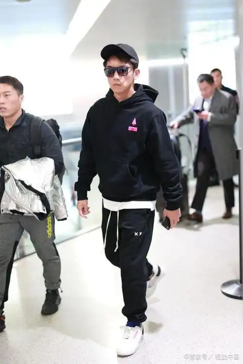 男演员郑恺现身机场,穿黑色卫衣粉红色图案十分亮眼,走路酷酷哒