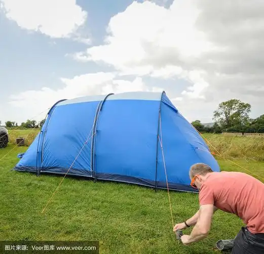 一个阴天,一名男子在英国萨默塞特切达的营地搭起帐篷