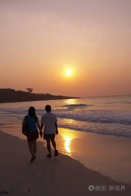 夫妻在黄昏时在海滩上散步