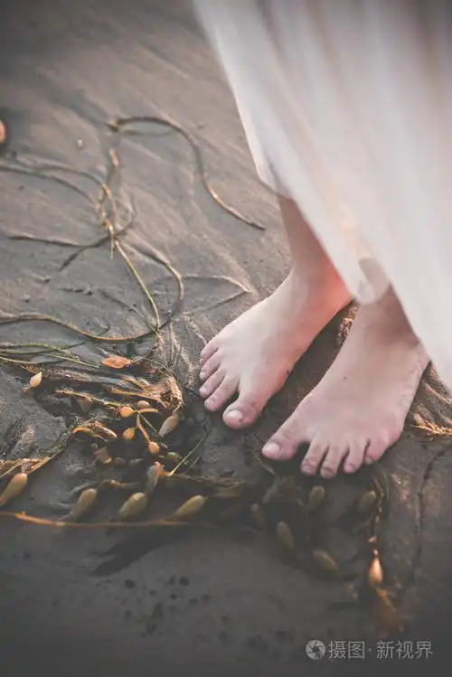 下午在沙滩上赤脚站着的女性照片-正版商用图片08o7c0-摄图新视界