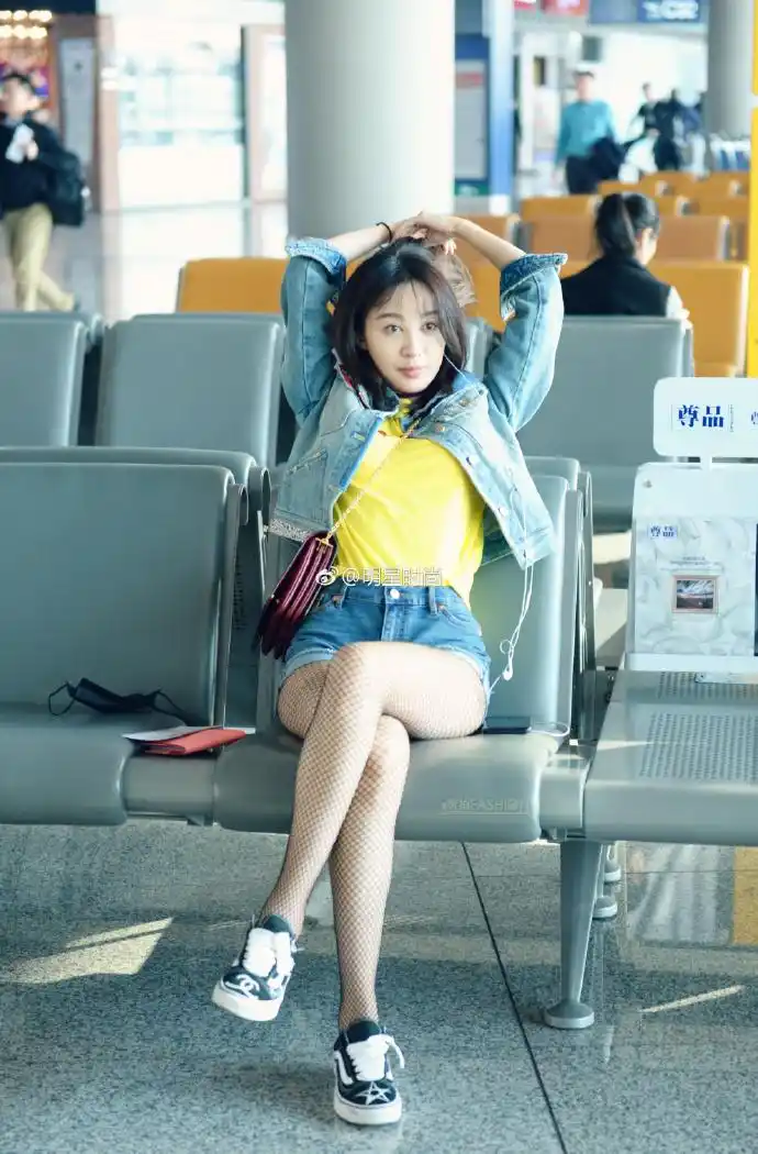 李菲儿北京机场街拍,她身穿牛仔外套搭配一条牛仔短裤 渔网袜大秀美腿