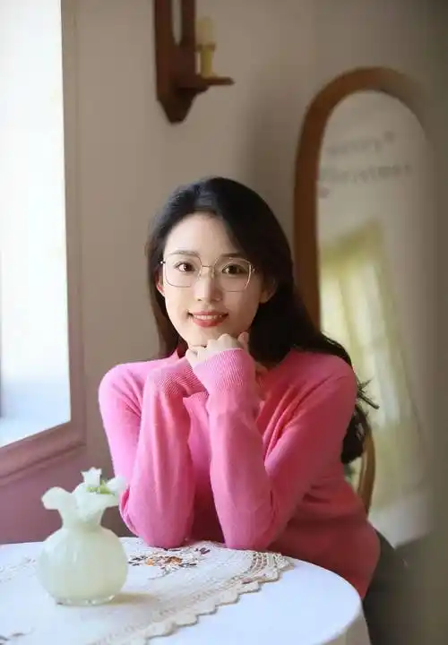 长发及腰戴眼镜的知性女孩穿红色上衣配黑裙子拍居家照温馨又浪漫