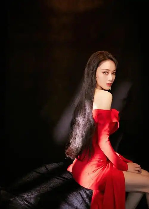 张馨予露背红裙#一身红色露肩设计高开衩礼服,黑色长发随风舞动,啡趑