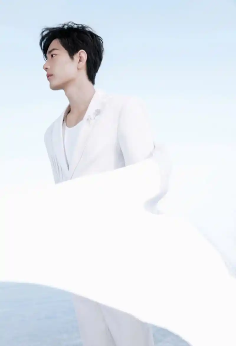 肖战身穿白色西装,一身白衣装扮干净帅气,笑容治愈,宛如白马王子