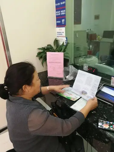 大堂经理向等候办理业务的客户,宣传大额现金试点工作.