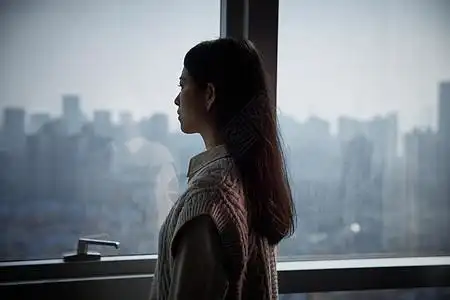 一个人孤单寂寞的惶恐青年女性独自在家看向窗外背景