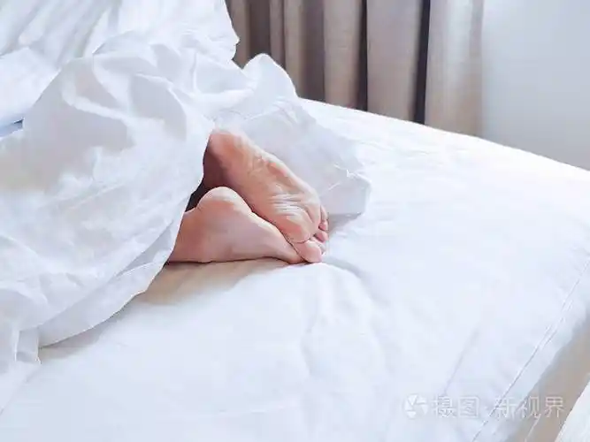 睡在白色床房的女人的脚一个年轻女人的脚我
