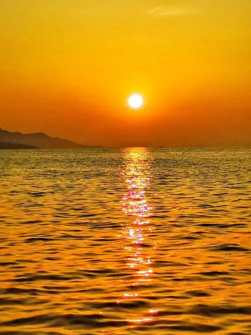 太阳慢慢升起来,把天空和大海都染成金红色.