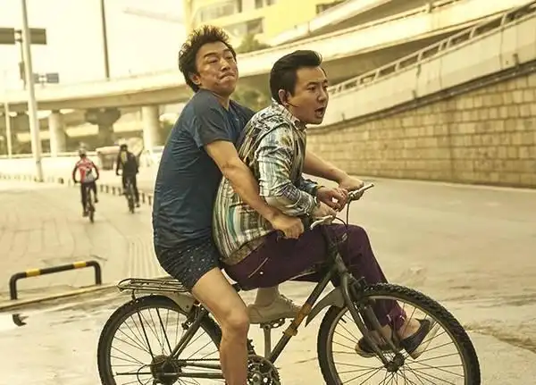 沈腾黄渤单车照火了有谁注意到周围人的穿着暴露演员的敬业