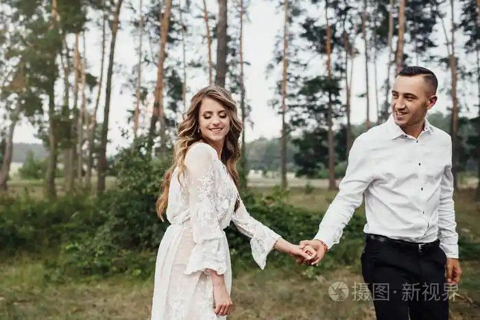 快乐的年轻夫妇相爱玩得开心拥抱在公园里