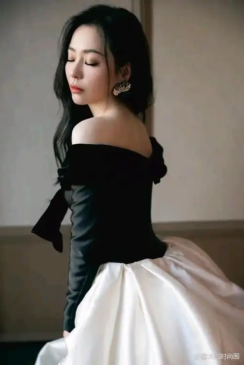张靓颖身着一套典雅的黑色与纯粹的白色相间的礼服,展现出她独特的的