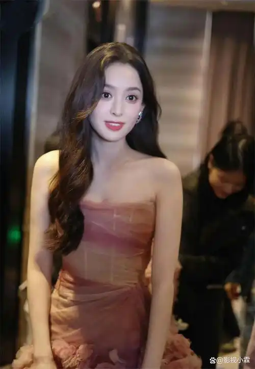 照片中,古力娜扎身着淡色抹胸裙,波浪秀发随风舞动,苗条的身材,雪白的