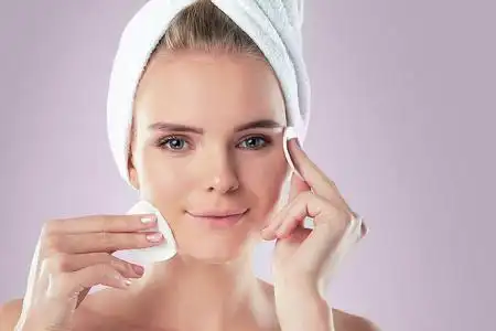 用爽肤水健康清新女孩用化妆棉卸妆.有海绵的女人皮肤有问题照片